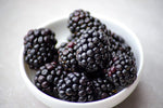 Blackberries in white porcelain bowl on white table