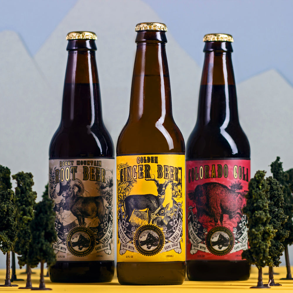 Three Rocky Mountain Soda bottles with miniature trees