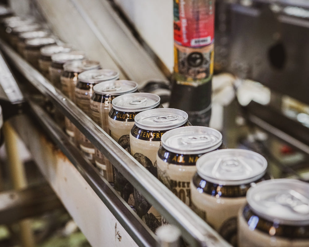 Line of Rocky Mountain Root Beer soda cans on production equipment